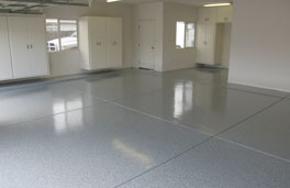 This image show a garage floor with flake epoxy that is gray in color.