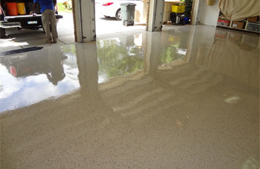 This image show a garage floor with flake epoxy that is cream in color.