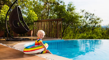 This image shows a kid playing on the pool side.