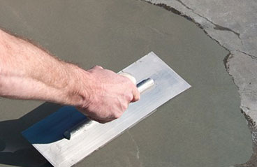 This image shows a man leveling the concrete.